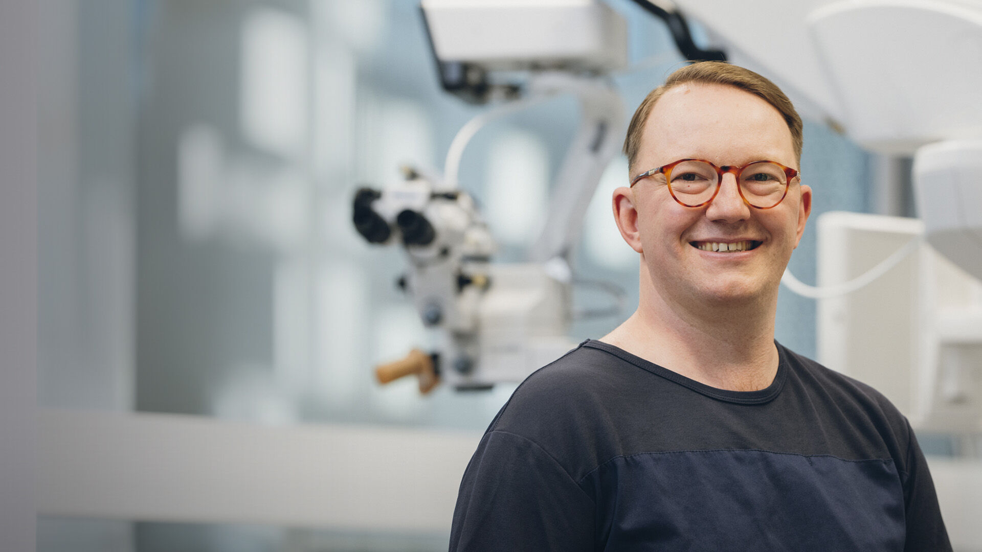 Silmäkirurgi hymyilee kameralle leikkaussalissa